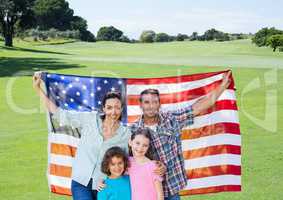 Family holding an american flag in park