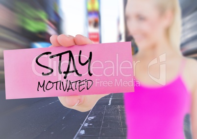 Woman holding placard that reads stay motivated against city
