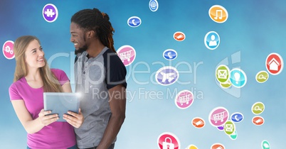 Couple holding digital tablet against digitally generated background