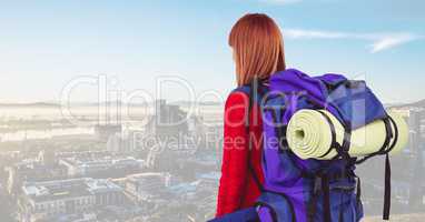 Female tourist with backpack and sleeping mat against cityscape