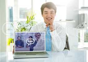 Portrait of smiling businessman showing laptop with video calling screen