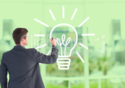 Businessman drawing electric bulb against office window background