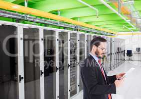 Businessman using digital tablet against database server systems in background