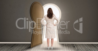 Woman standing against keyhole shaped doorway with light dark grey room