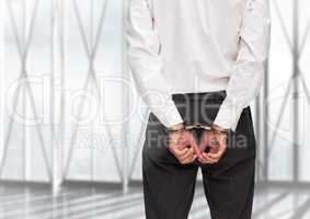 Rear view of guilty businessman with his hands cuffed