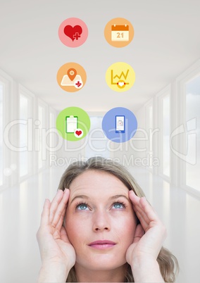 Woman looking at medical icons against hallway in background