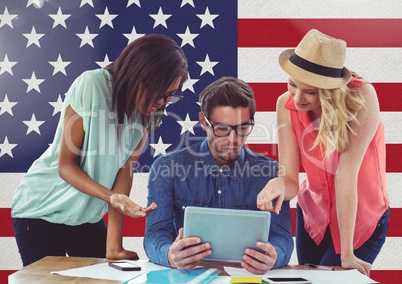 Friends using digital tablet against american flag in background