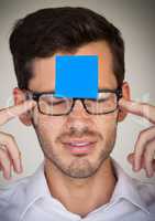 Stressed man with blank blue sticky note on his forehead