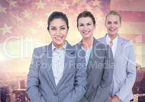 Portrait of confident businesswomen standing against cityscape and American flag