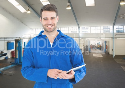 Mechanic holding digital tablet in garage