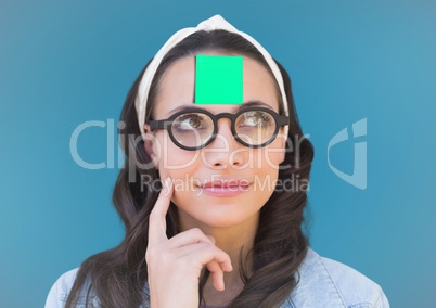Thoughtful female executive with sticky note on head against blue background