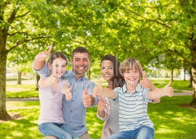 Family showing thumbs up in park