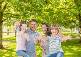 Family showing thumbs up in park