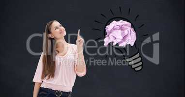 Smiling woman with crumbled paper on drawn light bulb in background