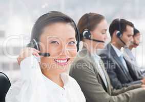 Portrait of happy woman talking on headset in call centre