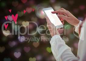 Woman using mobile phone against hearts in background