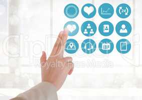 Doctor touching digitally generated medical icons against white background