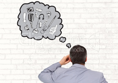 Rear view of businessman with thought bubble of various graphics