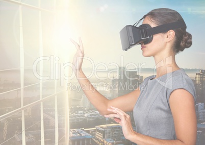 Businesswoman using virtual reality headset against office buildings in background