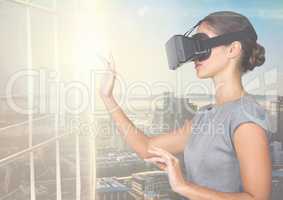 Businesswoman using virtual reality headset against office buildings in background