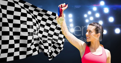 Athlete holding medals against checkered flag in stadium