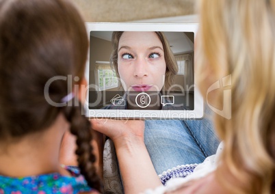 Mother and daughter having video calling in lving room