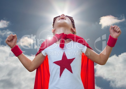 Kid in superhero costume screaming against sky in background