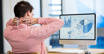 Tired man working on laptop at desk in office