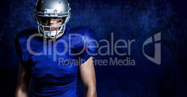 American football player wearing helmet standing against blue background