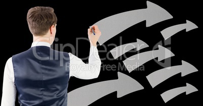 Businessman drawing against arrow symbols in background