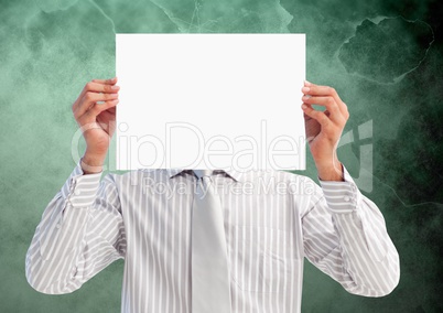 Businessman holding blank placard in front of his face against green background