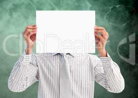 Businessman holding blank placard in front of his face against green background