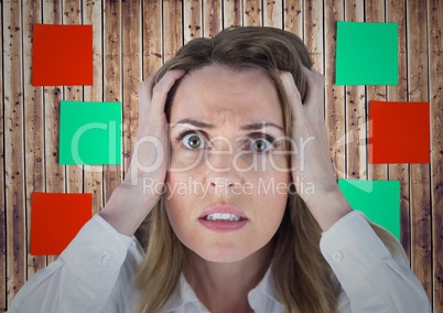 Frustrated woman with hands on her face against sticky note on wooden background