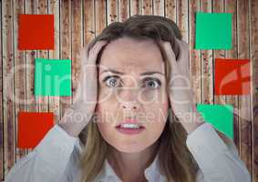 Frustrated woman with hands on her face against sticky note on wooden background