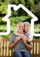 Senior couple sitting in the park with home outline