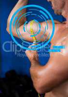 Fit man measuring his biceps at gym with fitness interface
