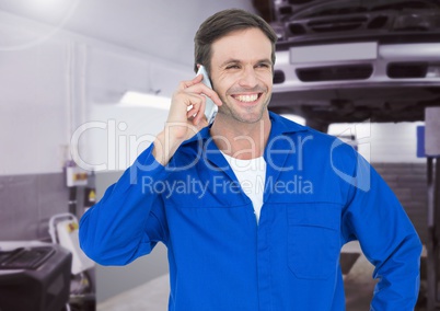 Mechanic talking on mobile phone at workshop