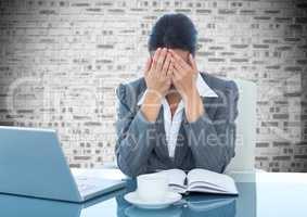 Depressed businesswoman sitting at desk with laptop and diary