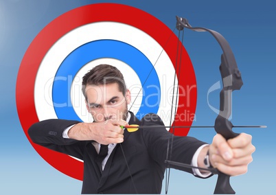Businessman aiming with bow and arrow against target in background