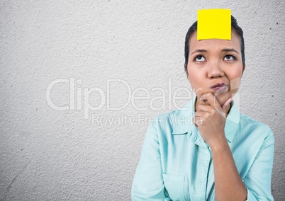 Thoughtful woman with sticky note on her forehead