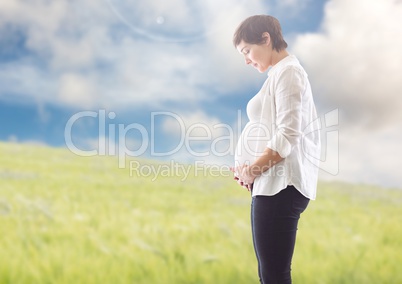 Smiling pregnant woman touching around the abdomen