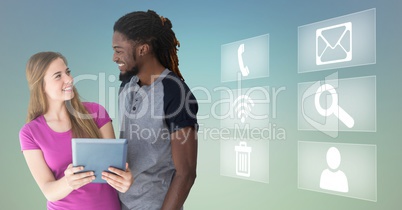 Happy man and woman holding digital tablet and various application icons in background
