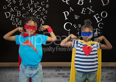 Kids in superhero costume flexing their arms against blackboard in background