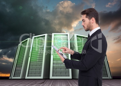 Businessman using digital tablet against server systems in sky