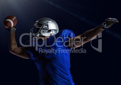 American football player throwing rugby ball against blue background