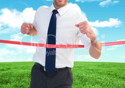 Businessman crossing finish line against sky and cloud