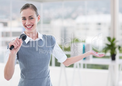 Businesswoman public speaking on microphone in office