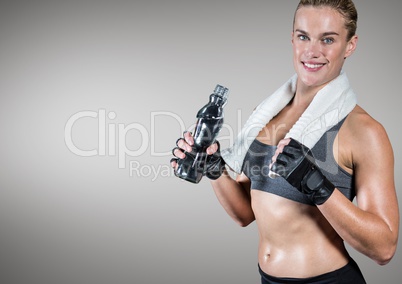 Fitness woman holding water bottle against grey background
