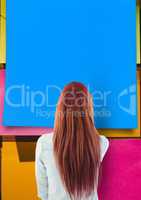 Rear view of woman looking at large blue sticky note