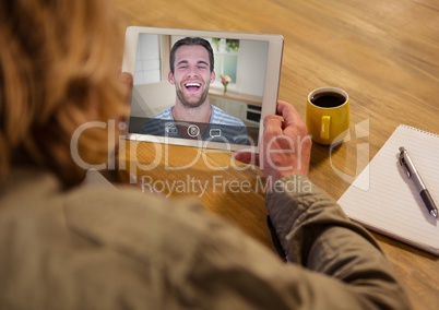 Woman having a video call with her friend on digital tablet
